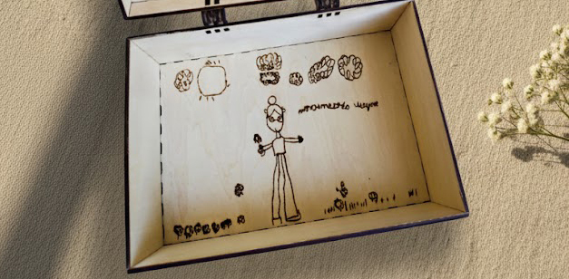 Vue intérieure d'un coffret en bois révélant la gravure laser d'un dessin d'enfant.