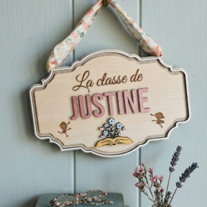 Cadeau maîtresse de fin d'année : plaque de porte en bois personnalisée suspendue par un ruban fleuri.